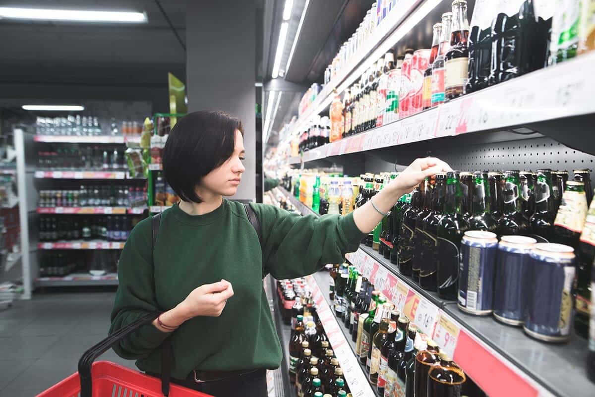 a woman shopping for alcohol showing signs of alcoholism