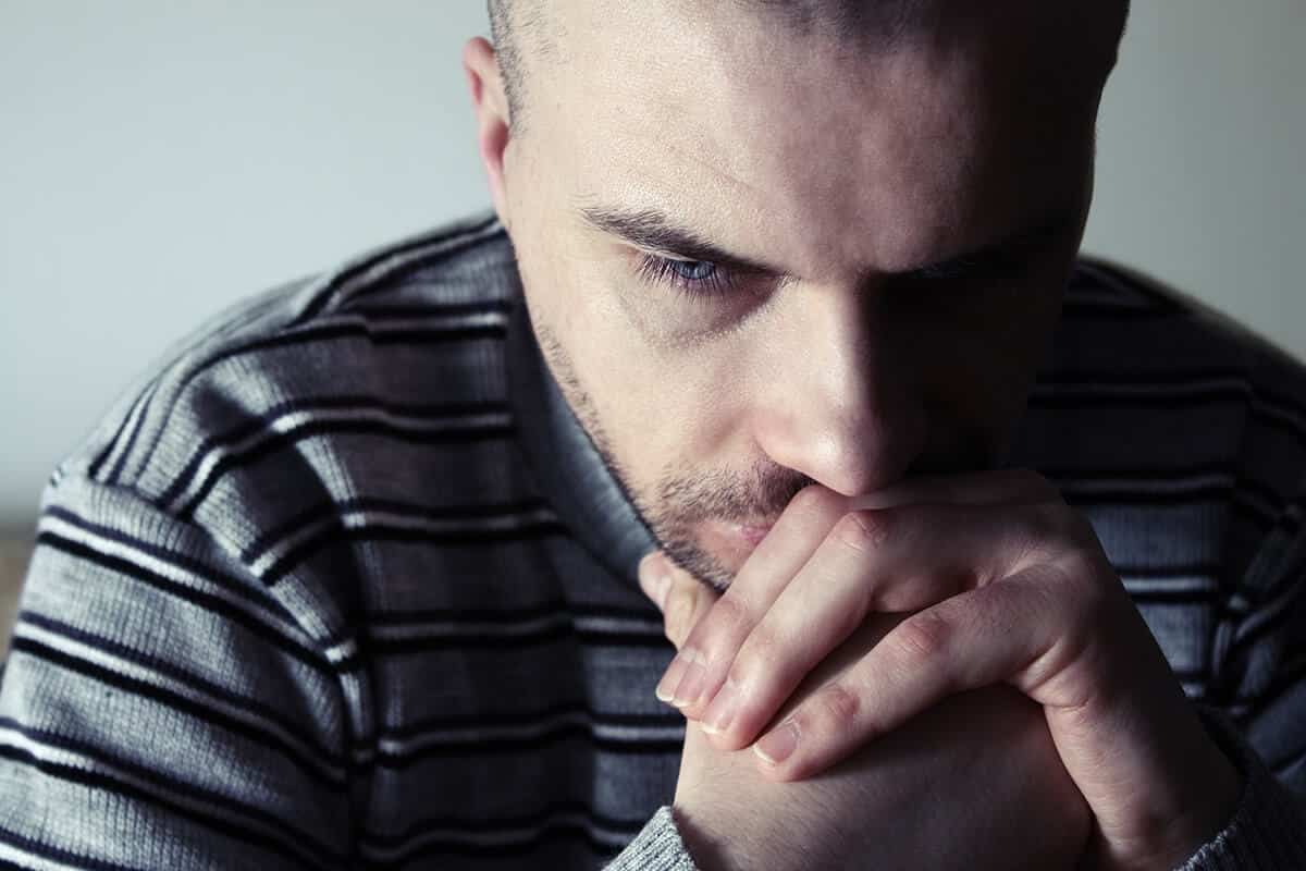 a man contemplating if he is suffering from the definition of withdrawal